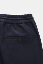 Close-up rear view of Incotex Cashmere Jogpants navy showing elastic waistband with drawstring, buttoned back pockets, zipper, and regular fit. Jersey made of pure cashmere, very soft touch, slightly tapered, French pockets, open length.