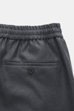 Incotex Woll-Jogpants dunkelgrau meliert, Detailaufnahme von oben auf elastischen Bund mit Tunnelzug, Gesäßtasche mit Knopf, reine Schurwolle, weicher Griff, Regular Fit, leicht schmal zulaufend, Reißverschluss und Bundknopf, Taschen in Seitennaht, offene
