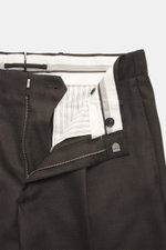 Nahaufnahme der geöffneten Incotex Wollhose dunkelbraun meliert, Frontansicht mit Reißverschluss, Bundknopf, elastischem Bund mit Tunnelzug, Canvas aus reiner Wolle, weicher Griff, Tapered Fit, reguläre Oberschenkelweite, knöchellang, doppelte Bundfalte, 
