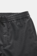 Close-up front view of Officine Générale Wool Jogpants 'Walter' dark grey melange showing elastic waistband with drawstring, zip fly, and side seam pocket. Parisian casualness with a modern touch: OFFICINE GÉNÉRALE presents the 'Walter' jogpants as a time