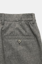 Nahaufnahme der Taille der GTA Hose 'Dennis' grau meliert, von oben fotografiert, aus Woll-Mix mit elastischer Qualität, Tapered Fit, französischen Taschen, Knopfleiste und fixiertem Saumaufschlag.