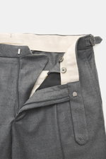 Close-up front view of GTA Wool trousers 'Herrick' dark grey melange showcasing lightly elastic virgin wool, soft touch, regular fit, low rise, zipper and waistband button, elastic insert in waistband, side adjuster, double waistband pleat, French pockets