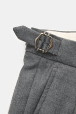 Close-up detail of the side adjuster buckle on the waistband of GTA Wool trousers 'Herrick' dark grey melange, photographed from above, showing lightly elastic virgin wool, soft touch, regular fit, low rise, zipper and waistband button, elastic insert in 