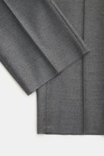 GTA Wool trousers 'Herrick' dark grey melange shown from a close-up top view, highlighting lightly elastic virgin wool, soft touch, regular fit, low rise, zipper and waistband button, elastic insert in waistband, side adjuster, double waistband pleat, Fre