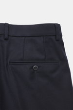 Nahaufnahme der Rückseite der GTA Wollhose 'Luca' navy, fotografiert von oben, zeigt Bund mit Waist Comfort Band, doppelte Bundfalte, paspelierte Gesäßtasche mit Knopf, aus edler Schurwolle mit leichter Twill-Struktur.