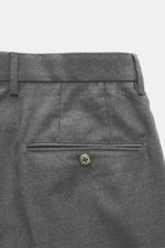 Back view close-up of GTA Wool Pants 'Luca' grey melange, showcasing the waistband with belt loops, piped back pockets with button, and fine twill texture. When refined tailoring meets invisible comfort, the cropped wool pants 'Luca' by GTA show their ful