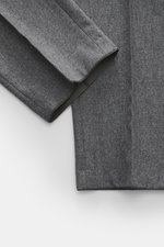 Hiltl Wollhose 'Piacenza' grau meliert, Detailaufnahme in schräger Draufsicht, reine feinste Wolle, weicher Griff, Regular Fit, gerader Schnitt, Reißverschluss und Bundknopf, französische Taschen, schmal paspelierte Gesäßtasche mit Knopf, offene Länge.