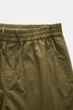 A close-up front view of A.P.C. Joggpants 'Pieter' oliv, showing the elastic waistband with drawstring, side seam pockets, and soft olive cotton twill fabric. <p>Sportives Hosenmodell von A.P.C.: mit komfortablem und elastischem Bund aus softem Baumwoll-T