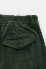 Detailaufnahme der grünen 04651/ A trip in a bag Cordhose mit knöpfter Gesäßtasche und teilelastischem Bund aus Baumwoll-Modal-Cord.