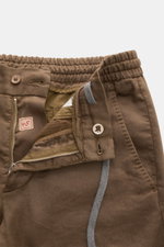 Nahaufnahme der geöffneten Marco Pescarolo Jogpants 'Caracciolo' braun mit Reißverschluss, Bundknopf, elastischem Tunnelzug und französischen Taschen.