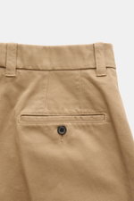 Close-up rear view of Thom Browne Chinos light brown showcasing pure cotton twill, jetted back pocket with button, and belt loops; eye-catching for spring with tapered fit, regular thigh width, ankle length, straight cut, zip and hook fastener, French poc