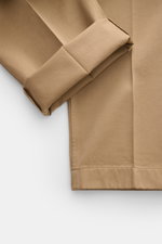 Close-up of Thom Browne Chinos light brown showing folded cuff and hem detail, photographed from above, made of pure cotton twill. Eye-catching for the spring season: With a tapered fit and firm twill fabric, these chinos from THOM BROWNE are a versatile 