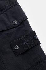 Close-up front-side view of Stone Island Cargo trousers 'Ghost Piece' dark navy in cotton and linen blend with tonal compass badge and snap-button cargo flap.