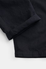 Stone Island Cargo trousers 'Ghost Piece' dark navy shown from a close-up side angle, highlighting the lightweight cotton and linen blend fabric, garment-dyed, with a straight cut and folded hem. Get an incognito look with these cargo pants from the 'Ghos