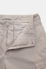 Stone Island Cargo pants 'Ghost Piece' beige shown from a close-up front angle with open zipper, button, and visible fabric texture. Get an incognito look with these cargo pants from the 'Ghost Collection' by Stone Island in a monochrome design that makes