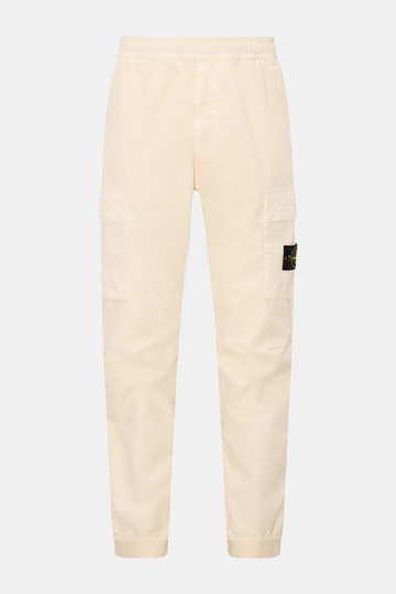 Front view of Stone Island Cargo jogger pants 'Regular Tapered' cream in organic stretch cotton with elastic waistband, cargo pockets, and signature badge.