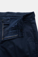 Close-up front view of 04651/ A trip in a bag Chinos navy, showing zip and waist button, French pockets, small woven label on waist, made of cotton twill with slightly elasticated, slightly robust fabric, tapered fit with regular thigh width, ankle length