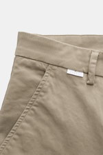 Nahaufnahme der Taille und Tasche der 04651/ A trip in a bag Chino taupe aus Baumwoll-Twill, leicht elastisch, Tapered Fit, knöchellang, mit Reißverschluss, Bundknopf, französischen Taschen und kleinem Weblabel.