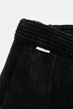 Close-up image of the waistband of the 04651/ A trip in a bag Corduroy cargo pants black, showing wide wale cotton corduroy with slight stretch, soft feel, tapered fit, regular thigh width, ankle length, slightly tapered cut, zip and waist button, partial