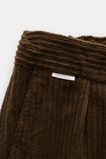 Nahaufnahme der oberen Bundpartie der 04651/ A trip in a bag Cord-Cargohose braun aus weichem Breitcord mit kleinem Weblabel, schmaler Bund.
