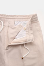 Brunello Cucinelli Jogpants 'Leisure Fit' sand shown from close-up top front angle, featuring twill linen-cotton, elastic waistband with drawstring, zipper, hook closure, and striped lining. 

<p>Stil trifft Tragekomfort: Die Jogpants von BRUNELLO CUCINEL