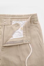Beige Brunello Cucinelli Jogpants 'Leisure Fit' shown from a close-up front perspective, featuring a twill linen-cotton blend, elastic waistband with drawstring, zipper, hook closure, and detailed pocket stitching. <p>Stil trifft Tragekomfort: Die Jogpant