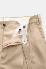 PT Torino Hose 'Carrot Fit' beige, Nahaufnahme von Bund und Reißverschluss, Mix aus Schurwolle und Leinen, schmaler Tapered Fit, doppelte Bundfalte, Knöpfe, Uhrentasche sichtbar.