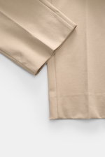Nahaufnahme der knöchellangen, schmal zulaufenden GTA Hose 'Davide' sand aus Baumwoll-Mix Jersey, seitlich fotografiert, Regular Fit.