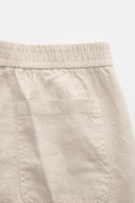 Close-up top view of 04651/ A trip in a bag Leinen-Jogpants 'Linen Pants' beige showing elastic waistband and back patch pocket, pure linen with typical texture, tapered fit, regular thigh width, ankle length, straight cut, elastic waistband, small woven 