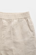 Close-up front view of 04651/ A trip in a bag Leinen-Jogpants 'Linen Pants' beige made of pure linen with elastic waistband, French pockets, and typical material texture, perfect for warm days, tapered fit, regular thigh width, ankle-length, straight cut,