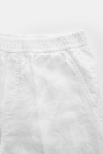 Close-up front view of 04651/ A trip in a bag Leinen-Jogpants 'Linen Pants' weiß showing elastic waistband, French pockets, pure linen fabric with typical texture, tapered fit, regular thigh width, ankle length, straight cut, small woven label, and patch 