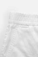 Close-up front-side view of 04651/ A trip in a bag Leinen-Jogpants 'Linen Pants' weiß, showing elastic waistband, typical linen texture, French pockets, and small logo label. Perfect for warm days: Die Leinen-Jogpants von 04651/ A TRIP IN A BAG werden zum