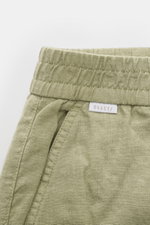Close-up top-front view of 04651/ A trip in a bag Leinen-Jogpants 'Linen Pants' salbei in light green pure linen with elastic waistband, typical linen texture, and small white woven label.  
<p>Perfekt für warme Tage: Die Leinen-Jogpants von 04651/ A TRIP
