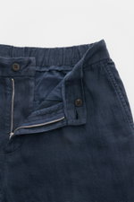 Close-up front view of 04651/ A trip in a bag Linen jogger pants 'Linen Pants' navy showing partially elasticated waistband, zip, button, and French pocket.

<p>Perfect for warm days: These linen jogger pants by 04651/ A TRIP IN A BAG are the ideal summer