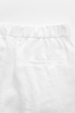 Close-up rear view of 04651/ A trip in a bag Linen jogger pants 'Linen Pants' white, showing pure linen fabric, partially elasticated waistband with drawstring, jetted back pocket, and signature material texture.

<p>Perfect for warm days: These linen jog
