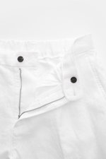 Close-up front view of 04651/ A trip in a bag Linen jogger pants 'Linen Pants' white, showing zip, button, and elasticated waistband.

Description: <p>Perfect for warm days: These linen jogger pants by 04651/ A TRIP IN A BAG are the ideal summer essential