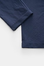 Close-up image from a top-down perspective showing the fixed hem turn-up of the navy seersucker fabric on the 04651/ A trip in a bag Seersucker trousers 'Technical Seersucker' navy. The trousers feature seersucker made of microfibre with a fine, typical m