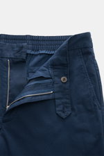 Frontansicht der geöffneten 04651/ A trip in a bag Baumwoll-Jogpants 'Flex Light' navy mit elastischem Bund, Reißverschluss, Bundknopf, französischen Taschen und schmal zulaufendem Schnitt.