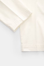 Close-up front view of 04651/ A trip in a bag Cotton jogger pants 'Flex Light' cream, elasticated cotton, soft feel, regular fit, short and very tapered cut with zip, waist button, partially elasticated waistband, small woven label, French pockets, and ba