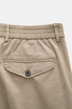 Detailaufnahme der Rückseite der 04651/ A trip in a bag Baumwoll-Jogpants 'Flex Light' taupe mit teilelastischem Bund, geknöpfter Gesäßtasche und weichem Griff.