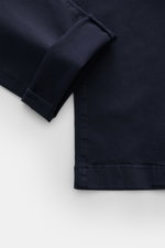 Close-up top-down view of the hem and cuff of the Jacob Cohen Chino 'Bobby' navy, showcasing slim fit, elastic pure cotton fabric, and tonal velour leather patch. Setzen Sie auf modernen Luxus im Alltag: Die schmal geschnittene Chino 'Bobby' von JACOB COH