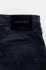Close-up rear view of Jacob Cohen Baumwollhose 'Nick' navy, showcasing the leather patch in pony fur look, tonal stitching, and five-pocket design. Setzen Sie auf modernen Luxus im Alltag: Die Five-Pocket-Hose "Nick" von JACOB COHEN kombiniert hochwertige