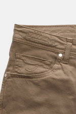 Close-up front view of Jacob Cohen Cotton trousers 'Nick' grey-brown showing five-pocket style, tonal stitching, elasticated soft cotton fabric, coin pocket with initial, button fly, and leather patch in pony skin look. Modern luxury for everyday wear wit