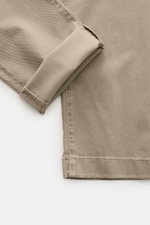 Close-up, angled top-down view of Jacob Cohen Pants 'Bobby' taupe showing folded cuff and twill fabric texture. Opt for modern luxury in everyday life: The slim-cut pants 'Bobby' by JACOB COHEN impress with soft twill made from cotton with lyocell, which 