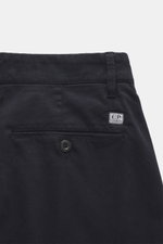 Nahaufnahme der C.P. Company Cargohose navy von hinten oben, reine Baumwolle, leichter Stretch, weicher Griff, Regular Fit, schmal zulaufend, Reißverschluss, Bundknopf, Seitentaschen, Cargo-Taschen, paspelierte Gesäßtaschen, labeltypisches Linsendetail.