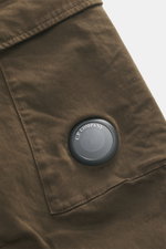 Nahaufnahme der C.P. Company Cargohose khaki von schräg oben, reine Baumwolle, leichter Stretch, Regular Fit, Cargo- und Gesäßtaschen, Linsendetail.
