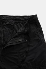 Close-up front view of Stone Island Cargo Pants 'Ghost Piece' Black showing elastic waistband, zipper, button, and tonal compass badge in lightweight microfiber.