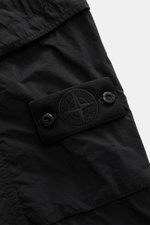 Close-up front view of Stone Island Cargo Pants 'Ghost Piece' Black showing the tonal compass badge on the thigh pocket made of lightweight microfiber with a smooth touch.