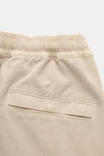 Close-up rear view of Stone Island Cargo Jogpants beige, showing elastic waistband and back pocket with snap button, made of soft organic cotton. For everyone who wants to combine function and style: These cargo jogpants by STONE ISLAND are inspired by cl