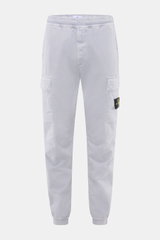 Front view of Stone Island Cargo Jogpants smoky blue, elastic organic cotton with stretch, tapered fit, zip fly, cargo and concealed zipper pockets, elastic waistband and leg cuffs, typical compass badge, darts at knees, back pocket with snap button.

Des
